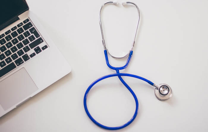 blue stethoscope and laptop