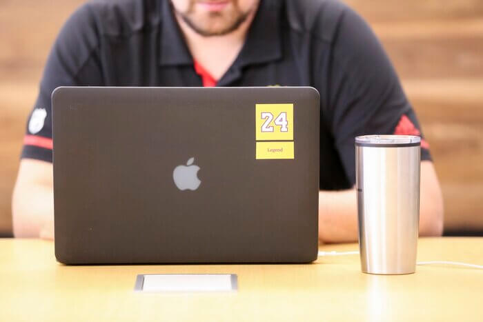 man in black jacket in front of macbook