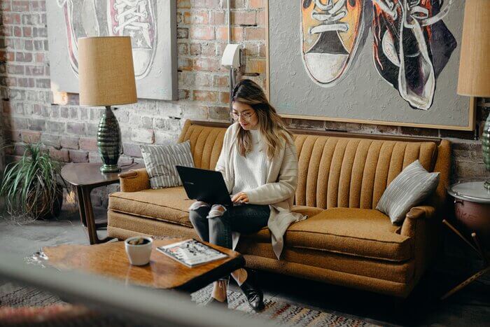 woman using laptop sitting on sofa