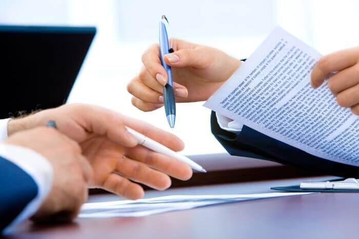 hands pointing on documents with a pen