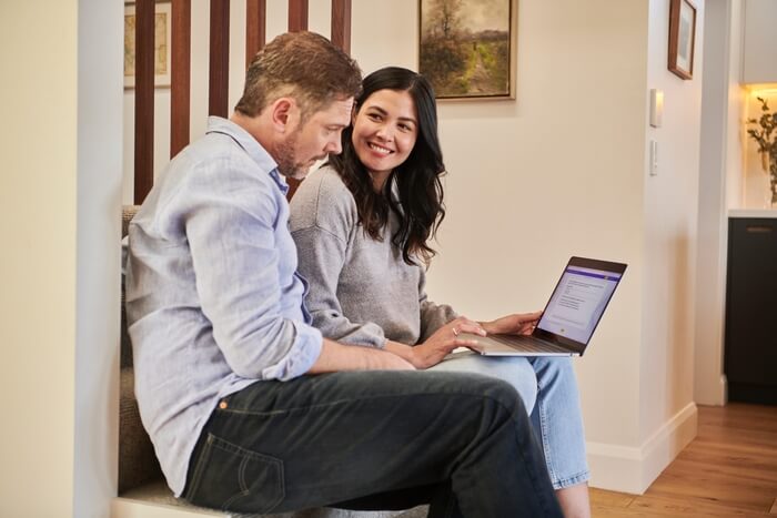 man and woman discussing work on laptop